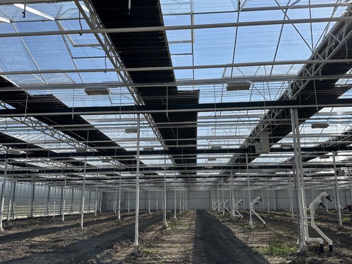 kas in aanbouw met schermdoeken die half open staan 