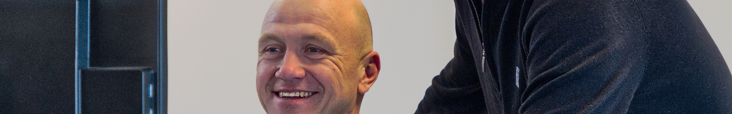 twee mannen lachend kijkend naar een computerscherm