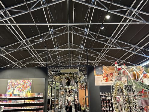 tuincentrum van binnen in kerstdecor met twee bezoekers en dichte schermdoeken