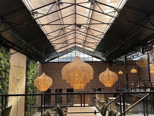 sjieke hal met grote lampen en een groene verticale planten wand