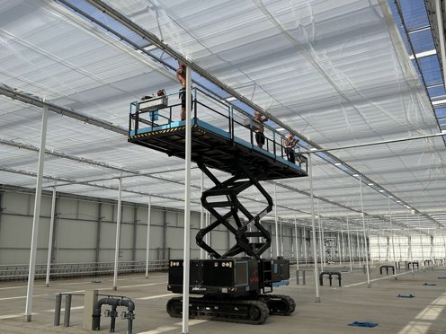 mannen installeren schermdoeken in een tuinbouwkas