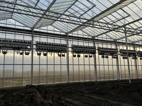 schermdoek installatie aan gevel van een kas in aanbouw