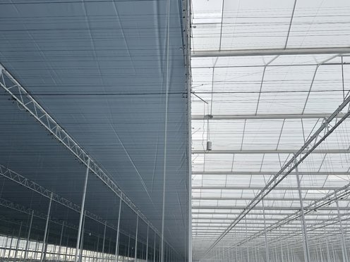 schermdoeken in de nok van een kas in aanbouw 