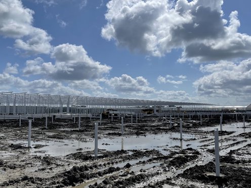 zeer modderige ondergrond waar een kasconstructie deels is geplaatst