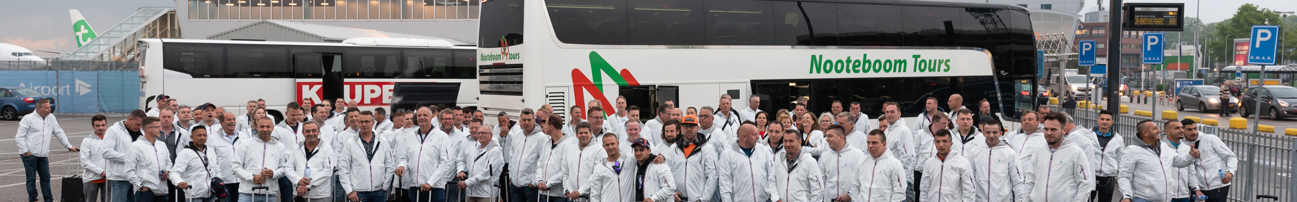 grote groep mensen met witte jassen voor 2 bussen