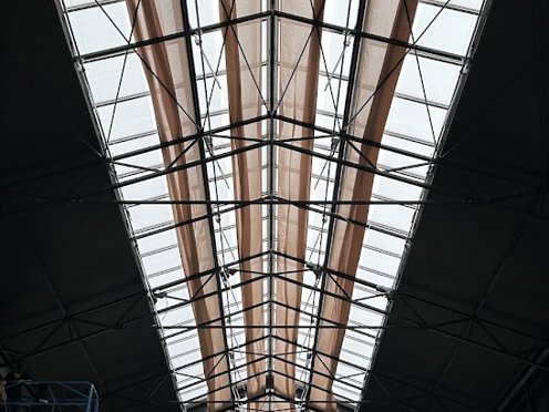 hoogwerker bij de bouw van een tuincentrum voor de schermen aan het glazen dak