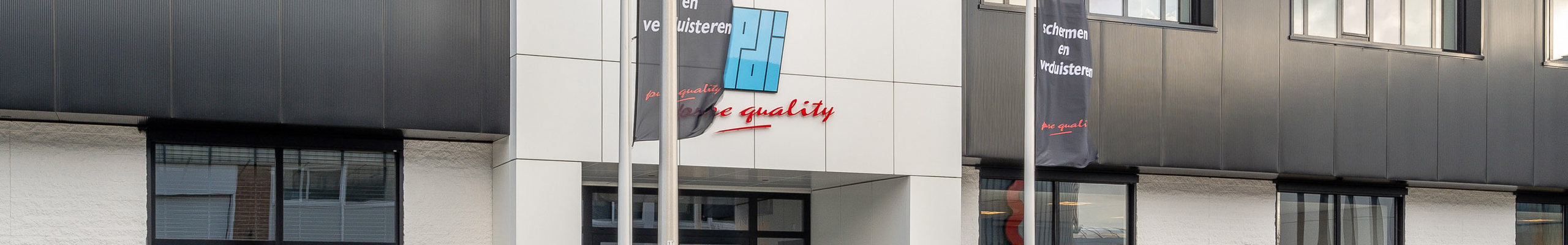 zwart wit kantoorpand met vlaggen bij de entree