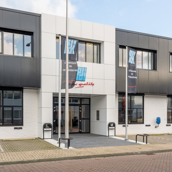 zwart wit kantoorpand met vlaggen bij de entree