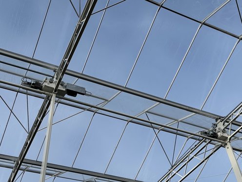 glas en staal van het dak van een tuinbouwkas van onderaf gezien op een zonnige dag
