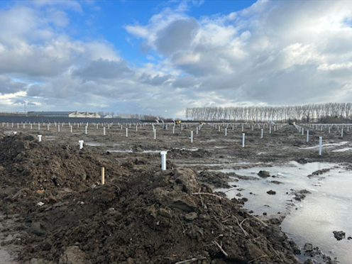 kas in aanbouw op open land met constructiepaaltjes