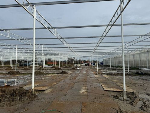 kas in aanbouw met modderige grond en rijplaten