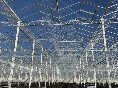 wit stalen kasconstructie zonder glas en felblauwe lucht