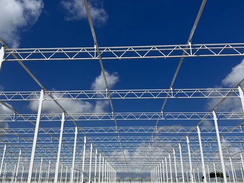 stalen kasconstructie voor een nieuwe tuinbouwkas op een stralende zonnige dag