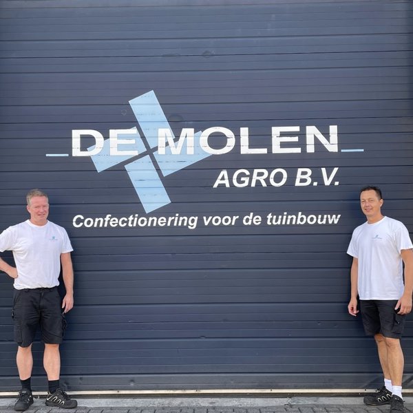 two men in front of a building both in white shirt and black shorts