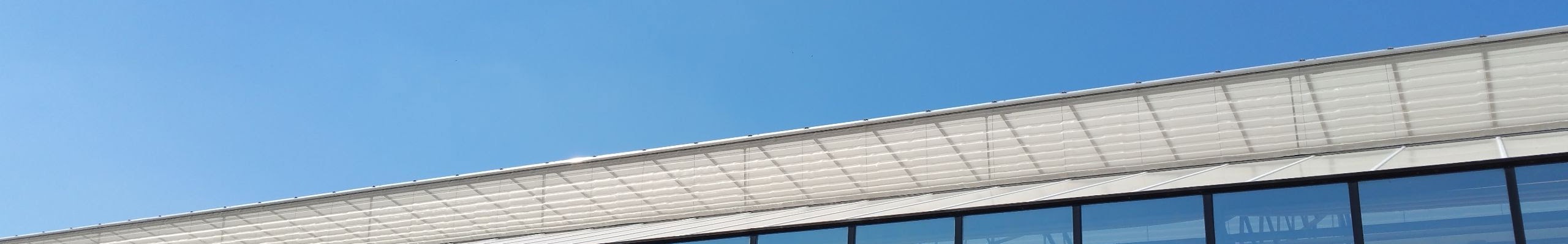 glazen bedrijf en blauwe lucht met bomen erin gespiegeld